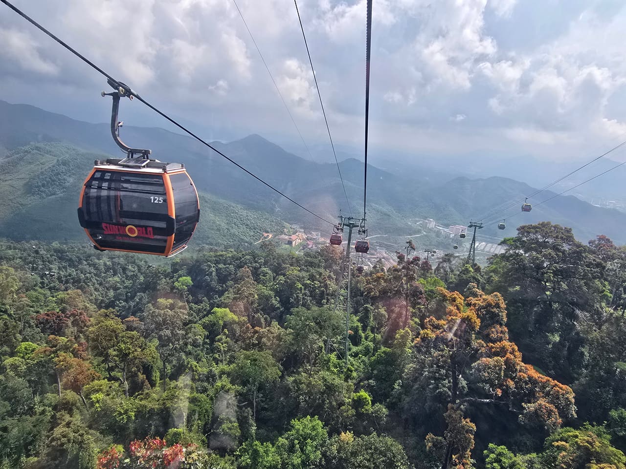 Cable car climbing over forested mountains to Bà Nà Hills