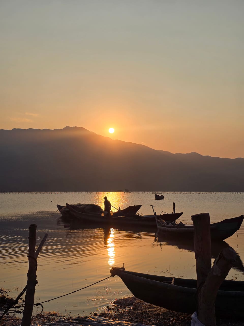 Fishing boats at sunset on the mirror-calm Lập An Lagoon